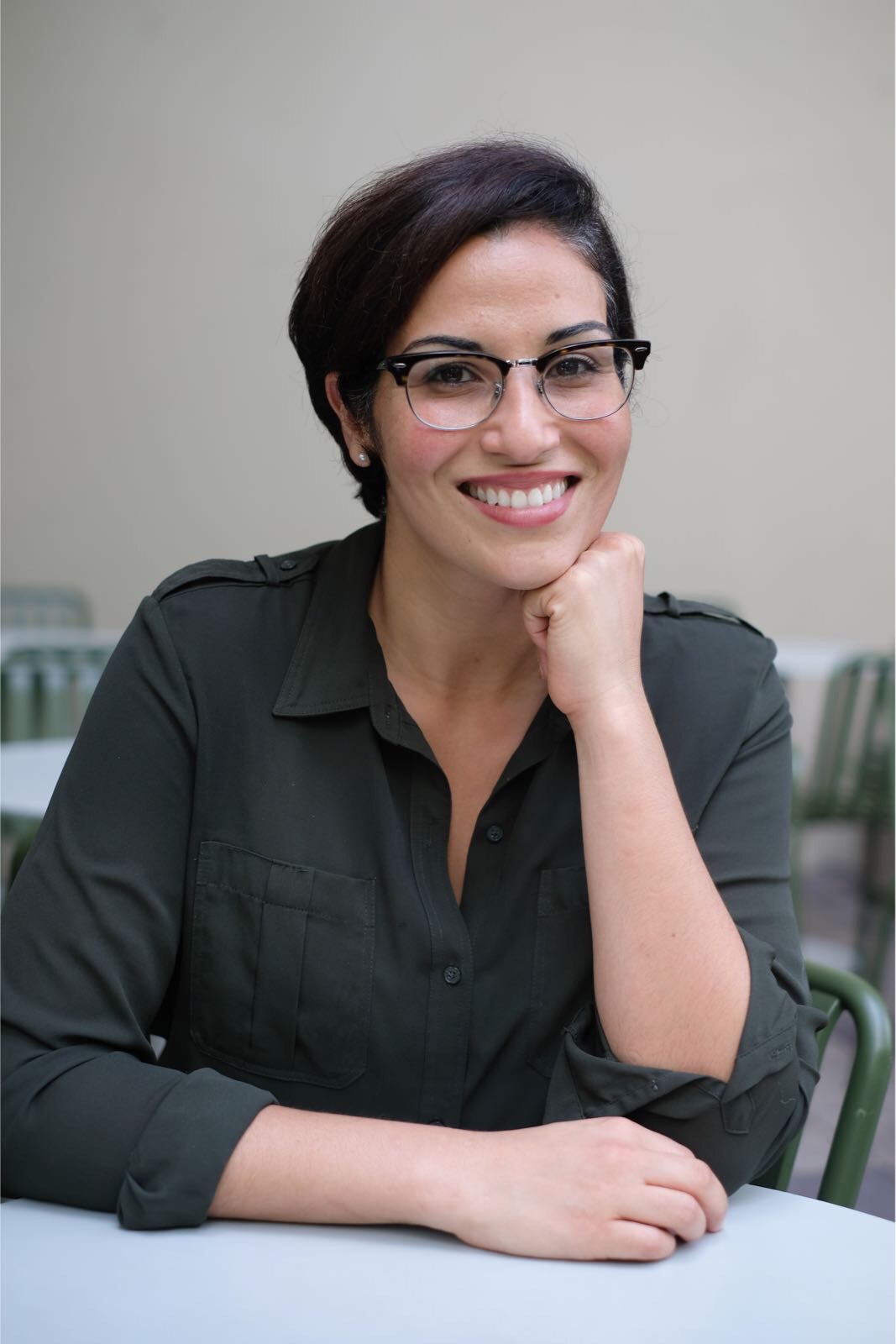 Elizabeth Espinosa, founder of Inspire Hospitality, smiling at a courtyard table
