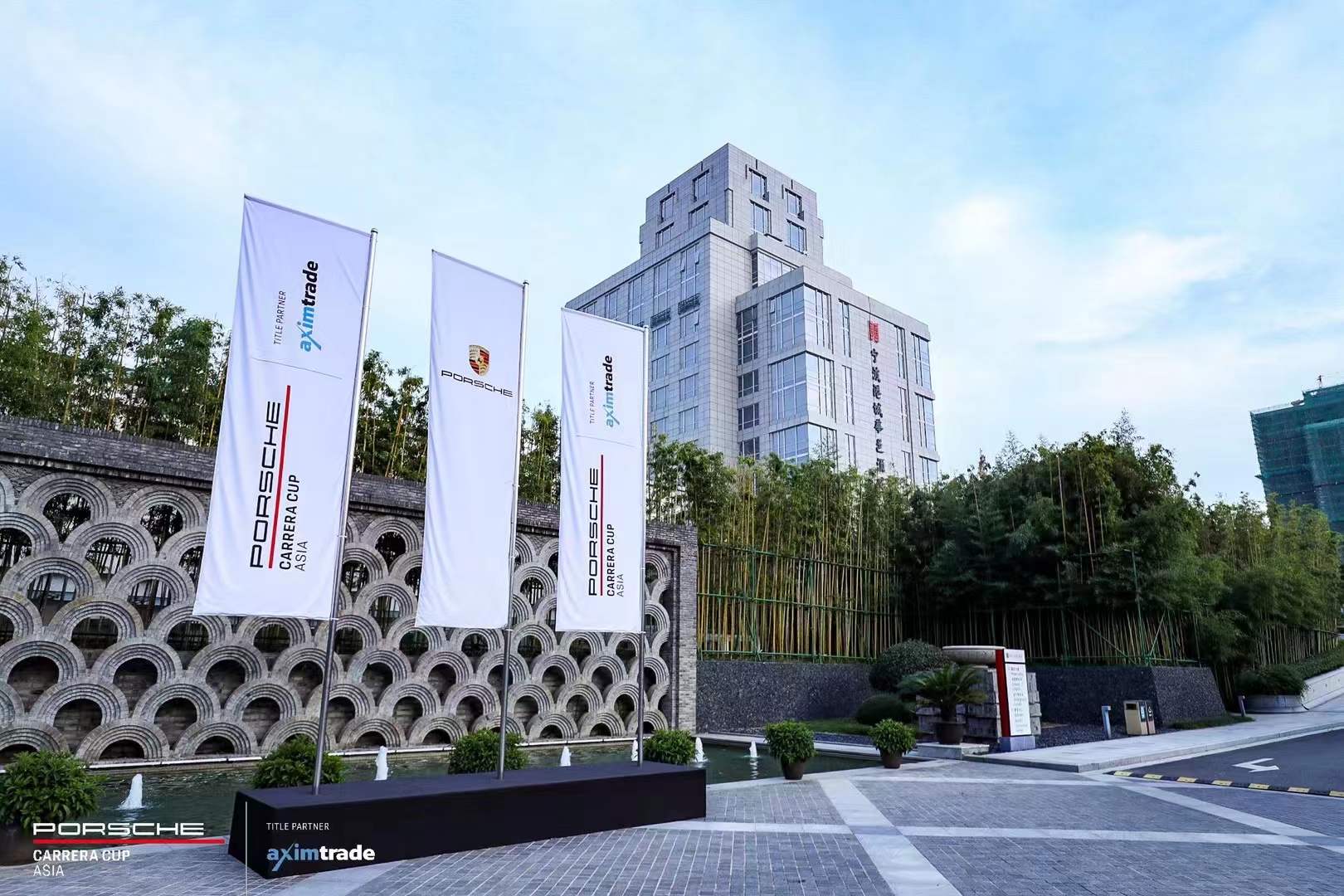 Porsche Carrera Cup Asia flags outside the host hotel against a bamboo backdrop
