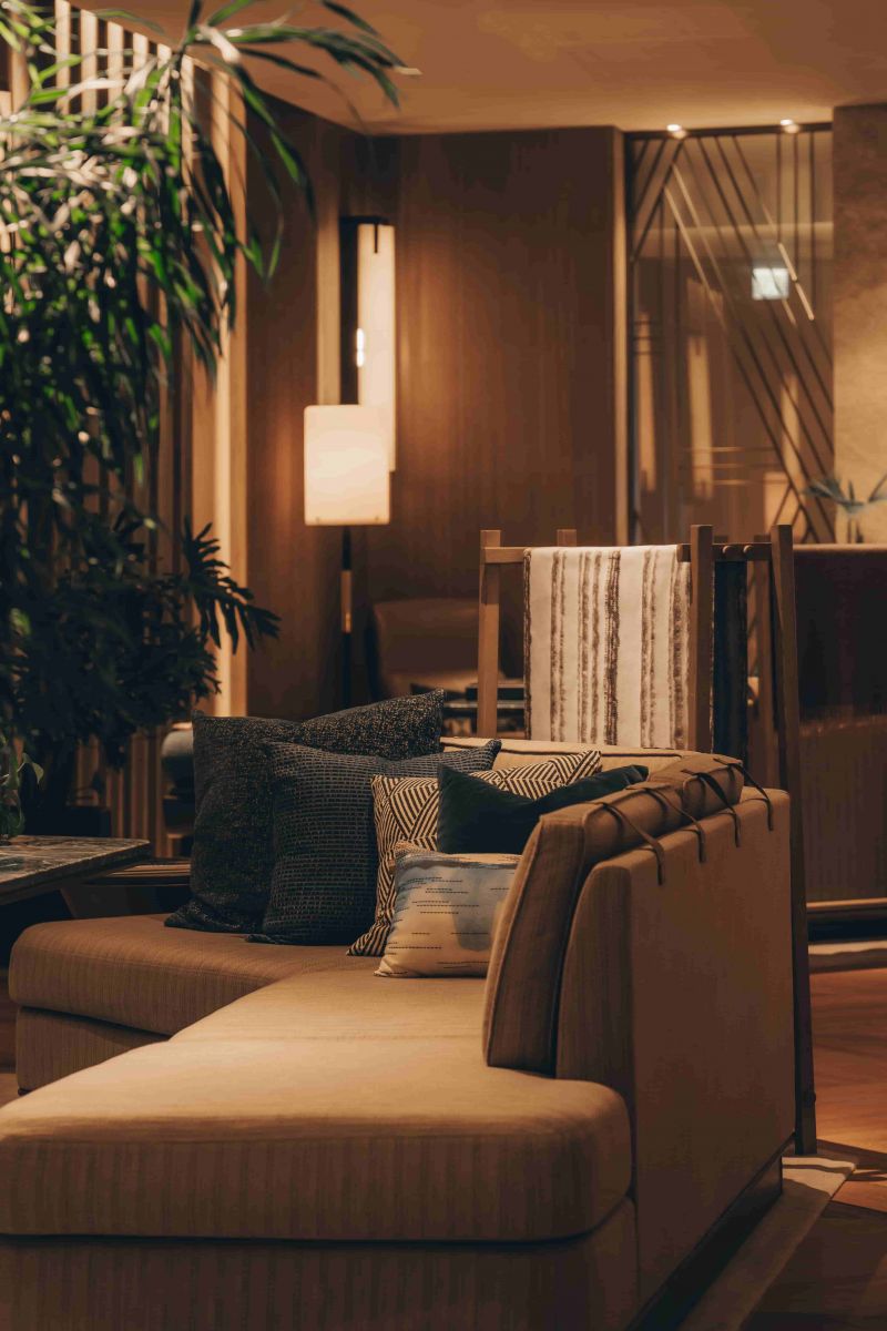 The Living Salon at K11 ARTUS, a warmly lit lounge of layered textiles and timber screens