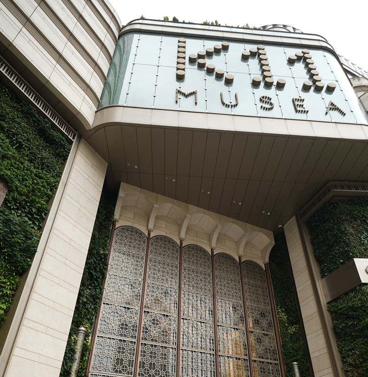 The K11 MUSEA entrance portal, its lettered canopy framed by arched screens and a living green wall
